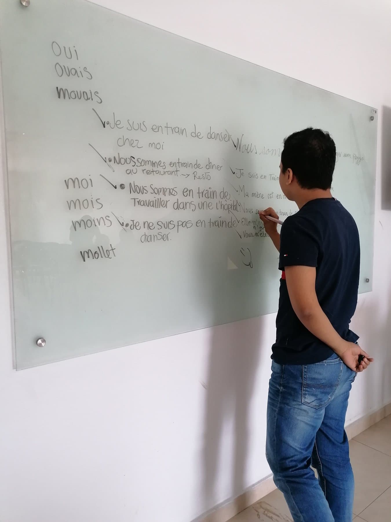 Escribiendo frases en francés en un tablero de vidrio